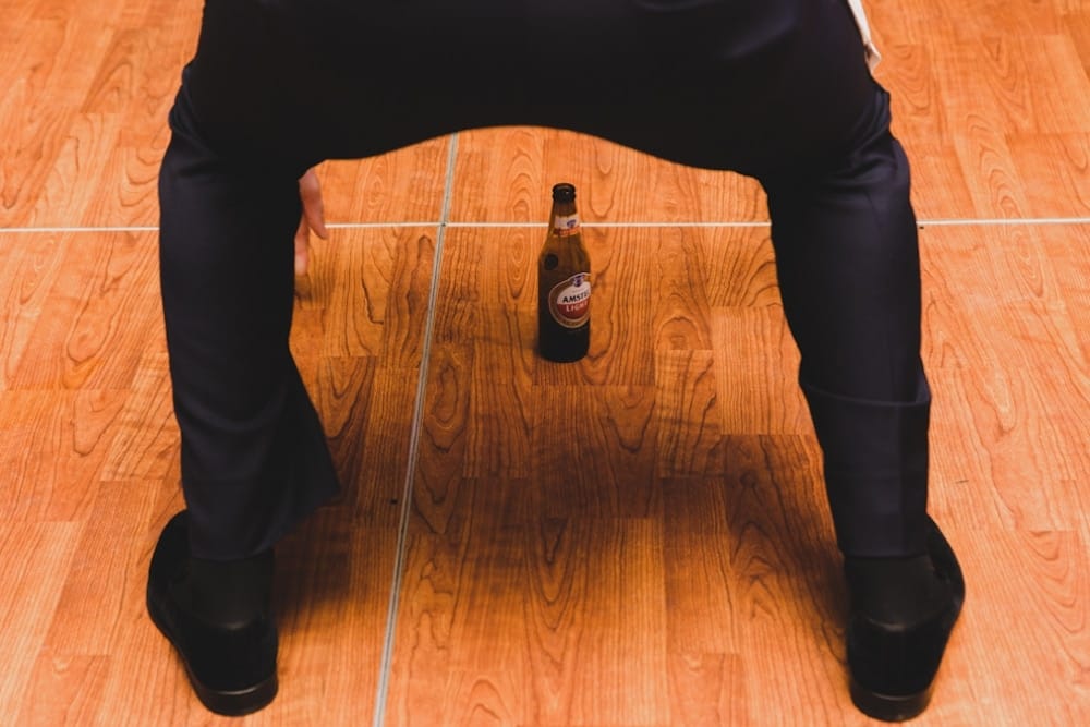A funny documentary photograph of a wedding guest dancing with a beer during a Castle Hill Inn Wedding in Newport, Rhode Island