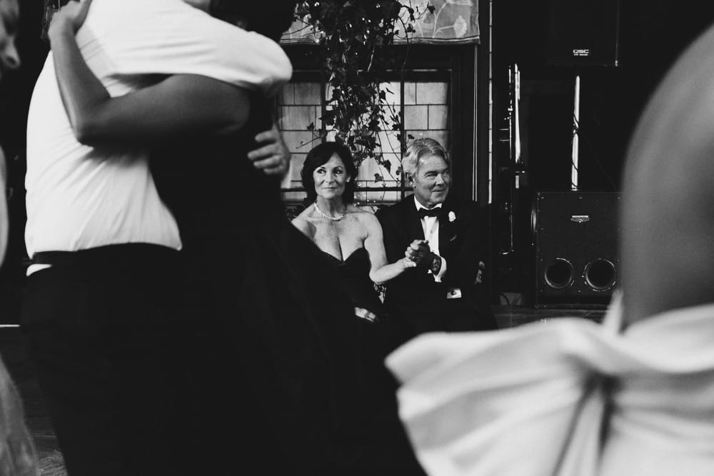 A documentary photograph of the bride's parents watching the dancing during a Castle Hill Wedding in Newport Rhode Island
