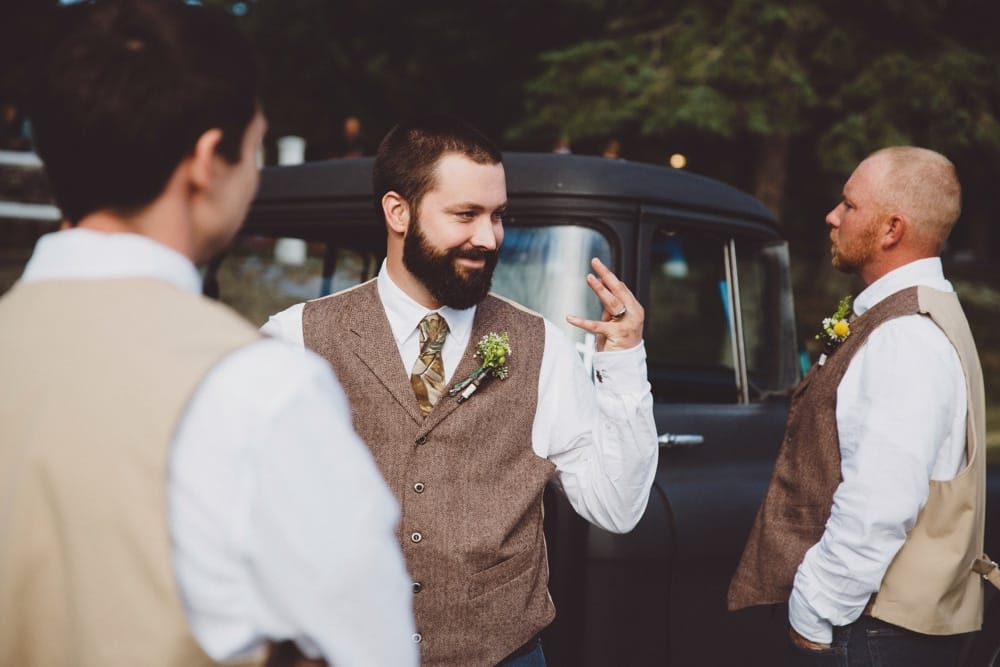 A funny documentary photograph of a groom showing off his wedding ring after his outdoor wedding ceremony at the River Club in Massachusetts