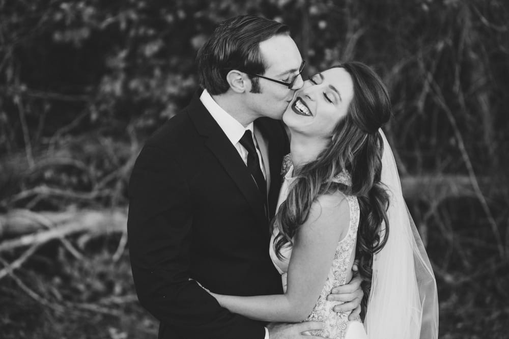 A beautiful relaxed wedding portrait of a groom kissing his bride during their wedding at Oceanview of Nahant in Massachusetts