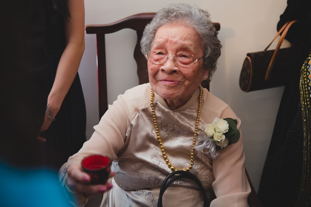 A documentary photograph of a grandmother wishing her granddaughter well during a vietnamese tea ceremony in Boston Massachusetts