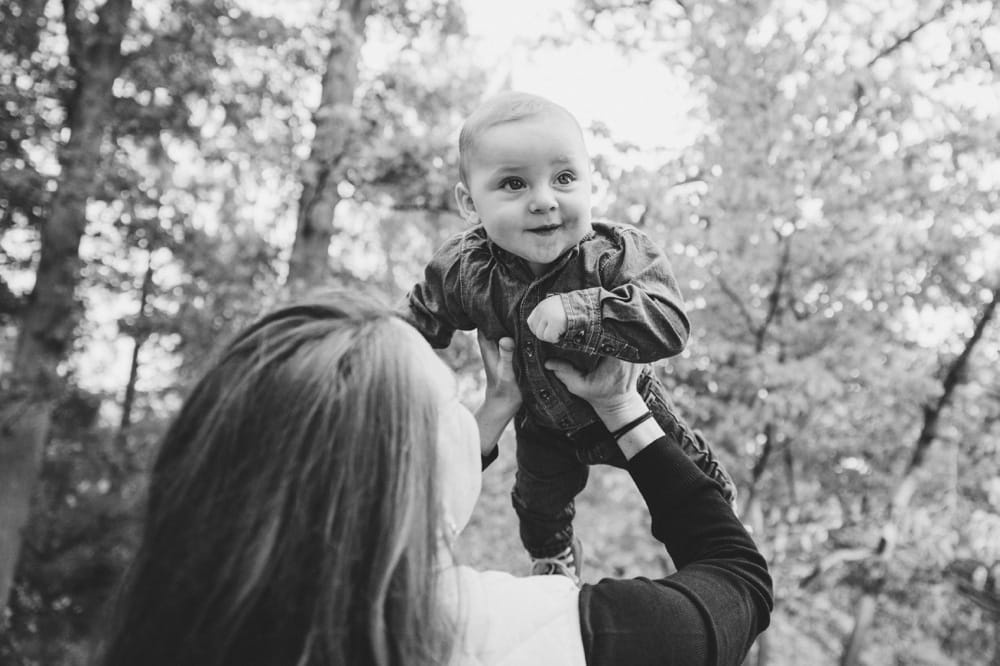 A documentary photograph of a mother playing with her baby boy during a lifestyle mini session at the Arnold Arboretum in Jamaica Plain, Massachusetts