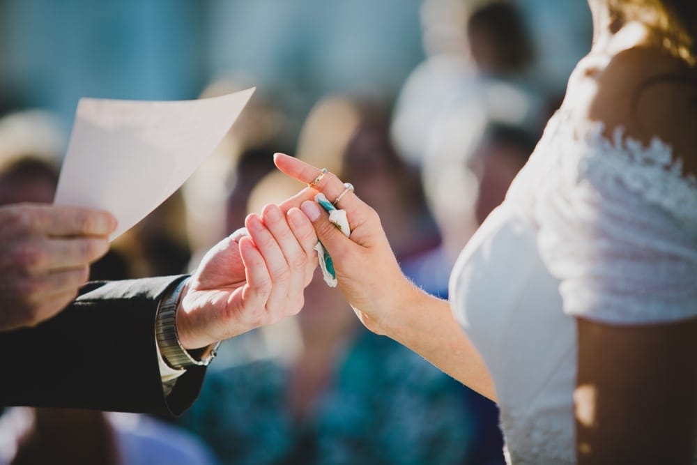 A photojournalistic photograph of a bride and groom saying their vows during an outdoor Jewish wedding ceremony in Cape Cod, Massachusetts