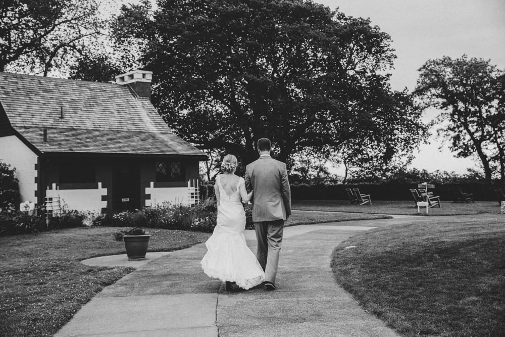 A documentary photograph of a bride and groom walking to their Cape Cod wedding reception at Pilgrim's Monument in Provincetown, Massachusetts