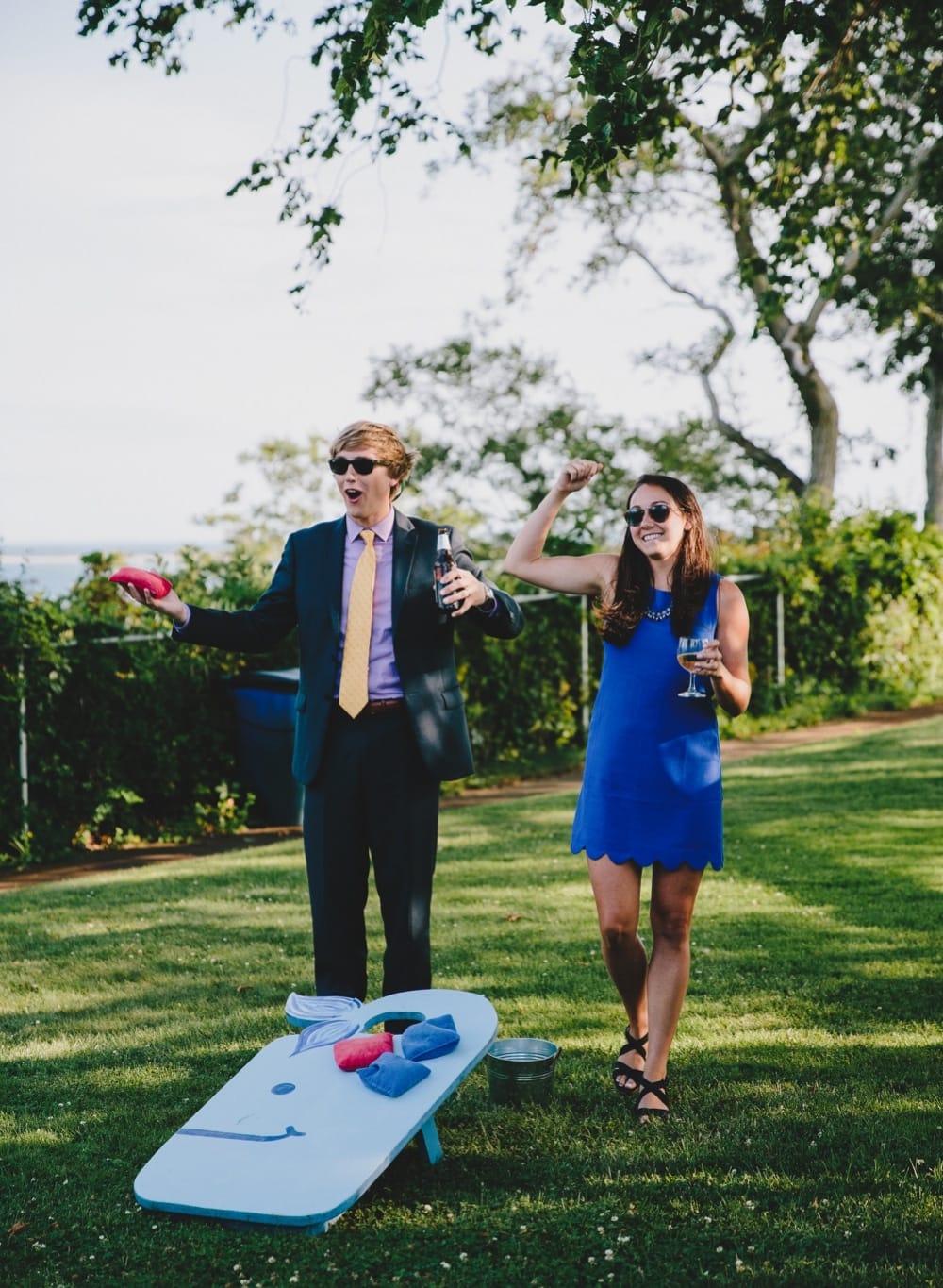 A documentary photograph of wedding guests playing lawn games during a fun summertime wedding at Cape Cod's Pilgrim's Monument in Provincetown, Massachusetts