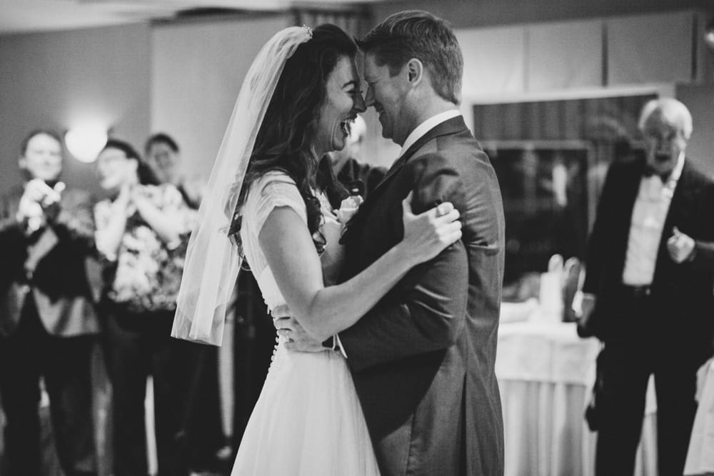 A documentary photograph of a bride and groom laughing during their first dance as husband and wife at their summer time Cape Cod wedding