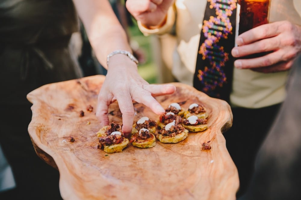 A photojournalistic photograph of a wedding guest enjoying the food during a fun summertime cocktail hour at a Pilgrim's Monument Wedding in Provincetown, Massachusetts