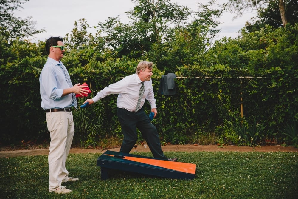 A fun photojournalistic photograph of two wedding guest playing lawn games during a fun summertime Cape Cod wedding at Pilgrim's Monument in Provincetown, Massachusetts