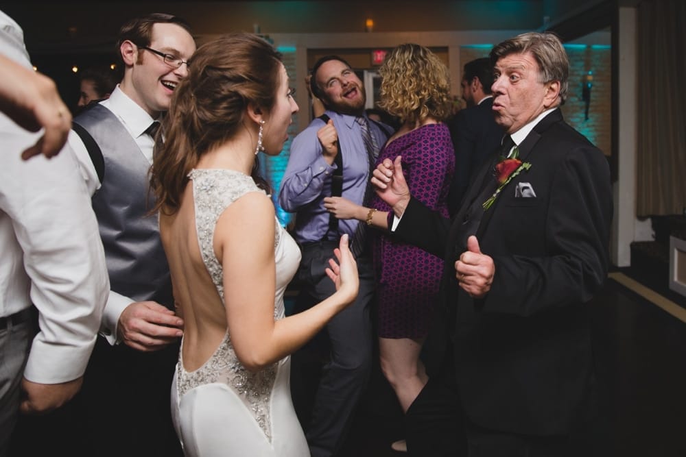 A photojournalistic photograph of wedding guest dancing during a fun and intimate Massachusetts wedding at the Oceanview of Nahant