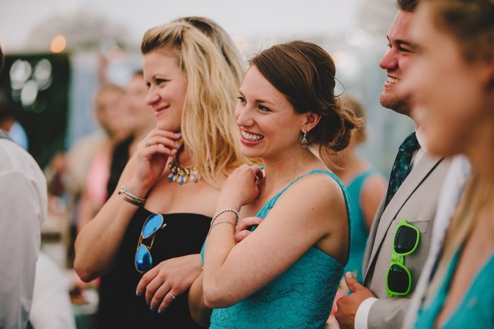 A photojournalistic photograph of wedding guest watching the bride and groom share their first dance during a fun, summertime Cape Cod wedding at the Pilgrim's Monument in Provincetown, Massachusetts
