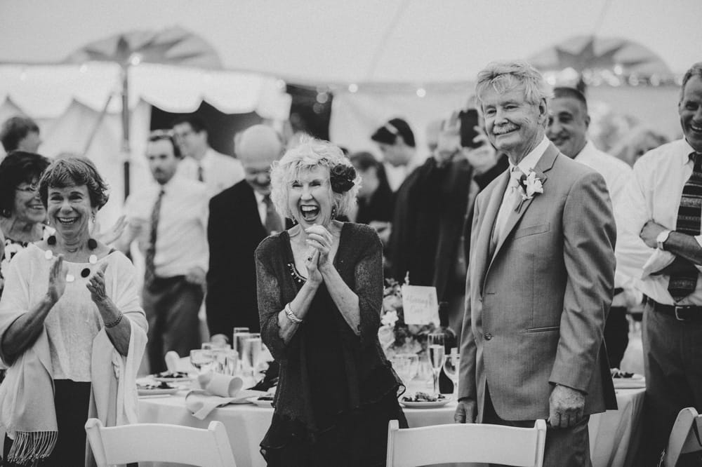 A documentary photograph of a mother of the bride clapping during her daughters first dance at Pilgrim's Monument Wedding Venue in Provincetown, Massachusetts