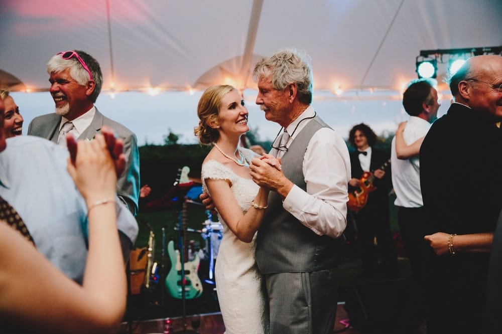 A photojournalistic photograph of a bride dancing with her father during a fun, summertime, Cape Cod wedding at Pilgrim's Monument in Provincetown, Massachusetts