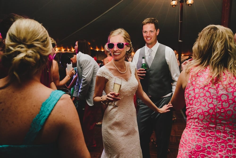 A photojournalistic photograph of a bride and groom dancing during their fun, summertime Cape Cod wedding at Pilgrim's Monument in Provincetown, Massachusetts