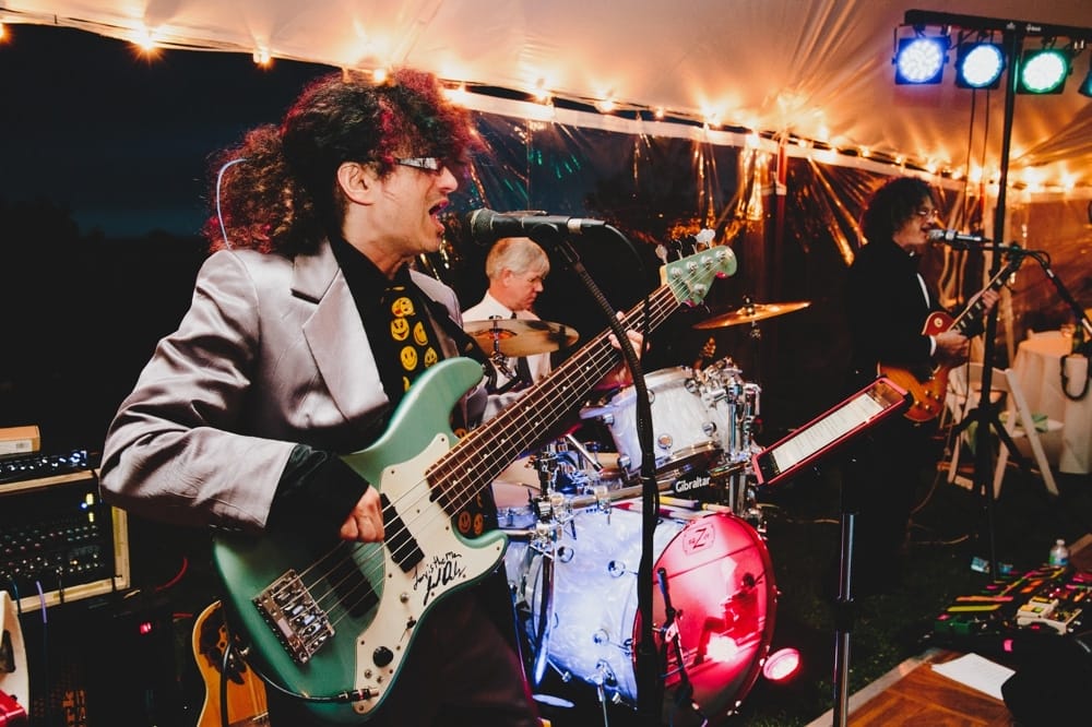 A photojournalistic photograph of a band playing at a fun, summertime Cape Cod wedding at the Pilgrim's Monument in Provincetown, Massachusetts