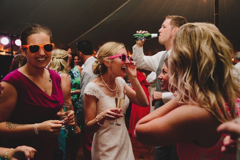 A fun photojournalistic photograph of a bride dancing with her friends during her fun, summertime, Cape Cod wedding at the Pilgrim's Monument in Provincetown, Massachusetts
