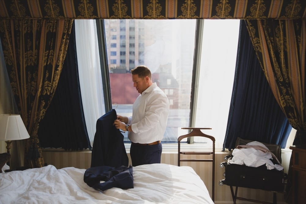 A documentary photograph of a groom getting ready for his State Room Wedding at the Langham Hotel in Boston