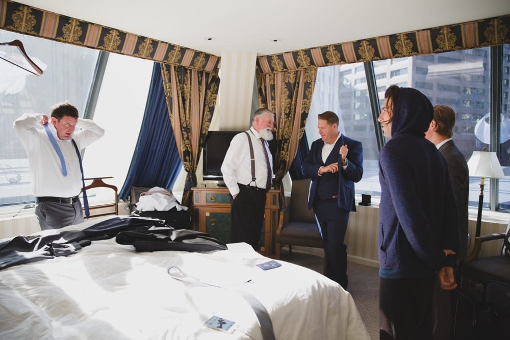 A documentary photograph of a Groom getting ready for his State Room Wedding with his family at the Langham Hotel