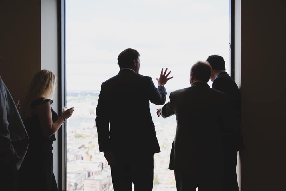 A photojournalistic photograph of guests enjoying the view during a State Room Wedding in Boston