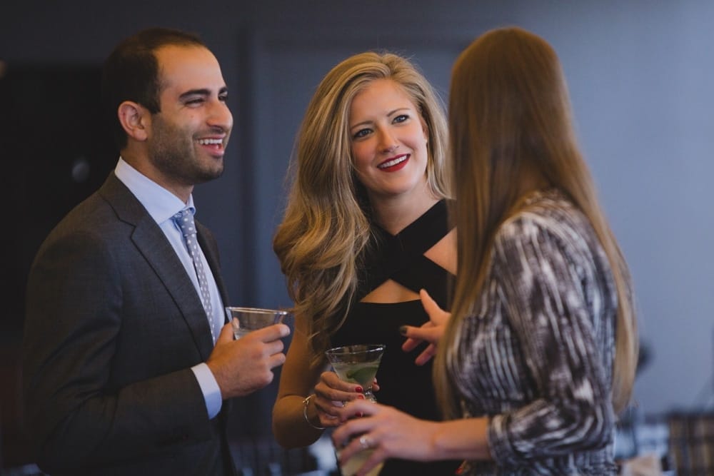 A documentary photograph of guests talking and laughing during a State Room Wedding in Boston