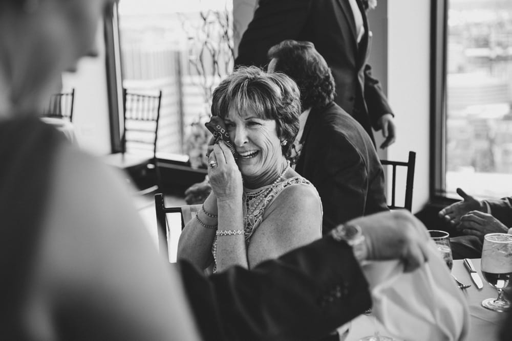 A photojournalistic photograph of the mother of the bride crying during the wedding speeches at a State Room Wedding in Boston
