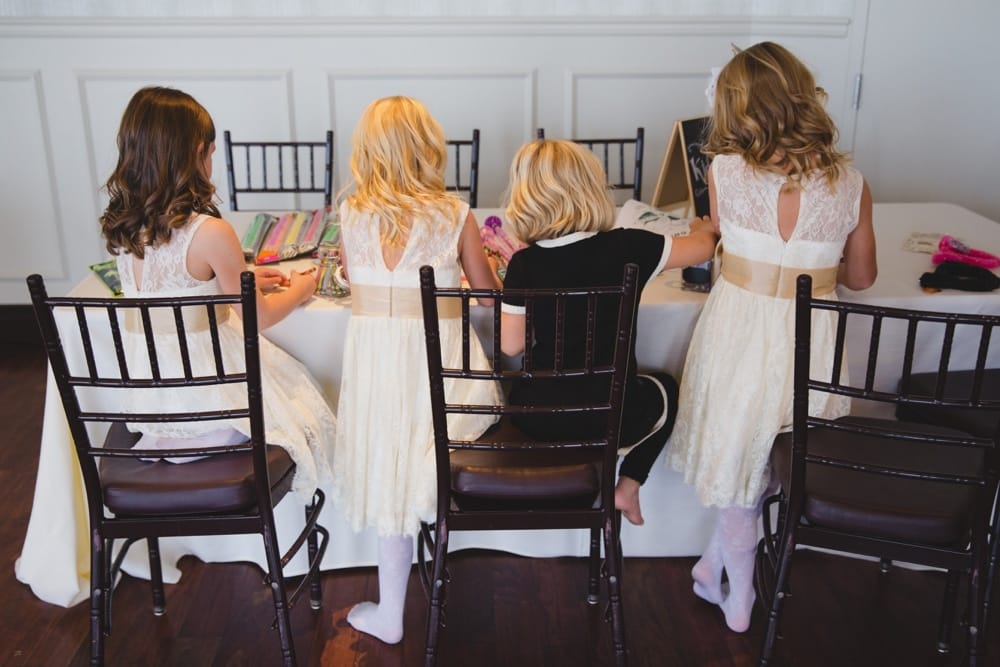 A documentary photograph of flower girls coloring at their kids table during a State Room Wedding in Boston