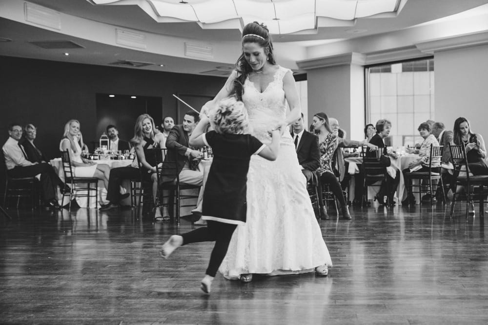 A documentary photograph of the bride dancing with a little girl during her State Room Wedding in Boston