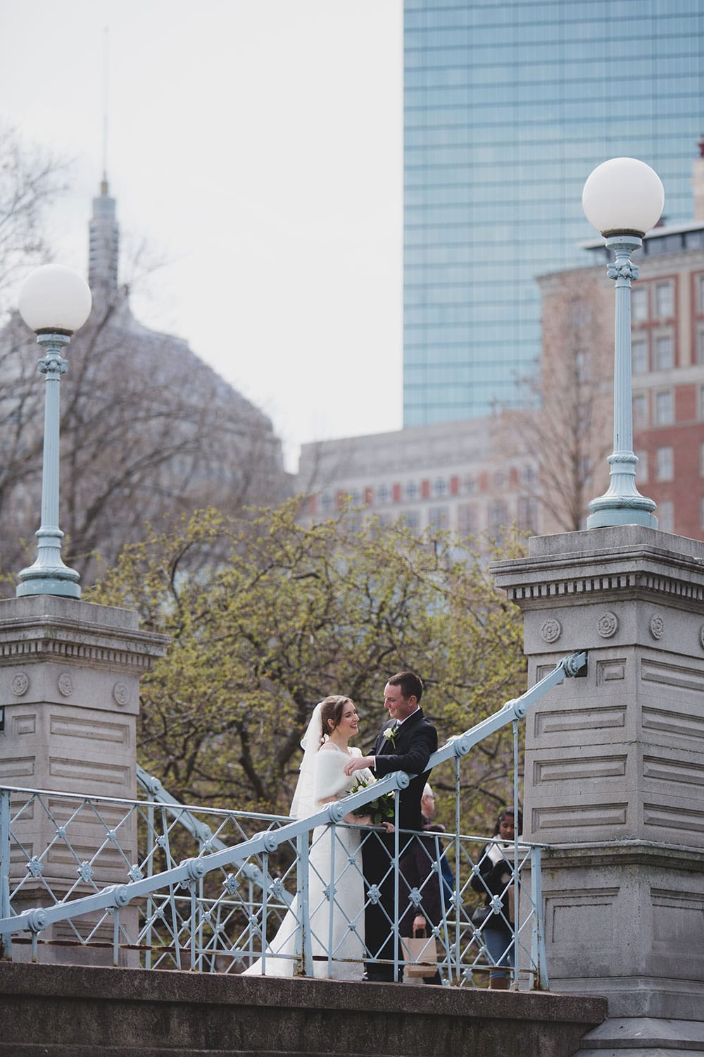 A documentary photograph of a bride and groom laughing together during their Wedding Portraits in Boston Public Gardens and Beacon Hill