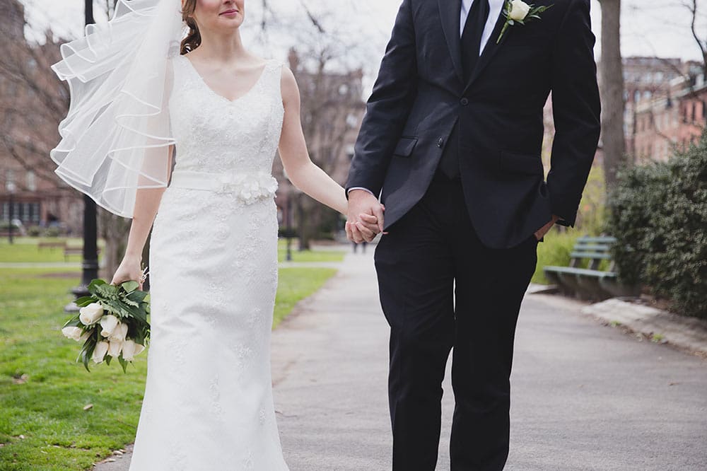 An artistic portrait of a wedding couple walking together during their wedding portrait session in Boston Public Gardens