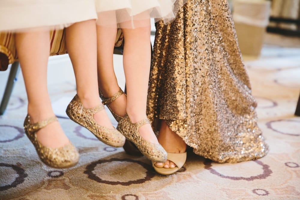 A documentary photograph of two twin flower girls sitting with their mom before a Taj Boston Hotel Wedding