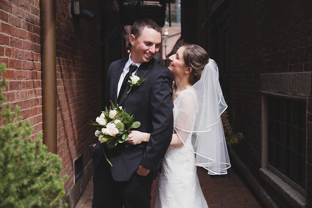 A sweet and natural portrait of a bride and groom laughing together during their wedding portrait session in Beacon Hill
