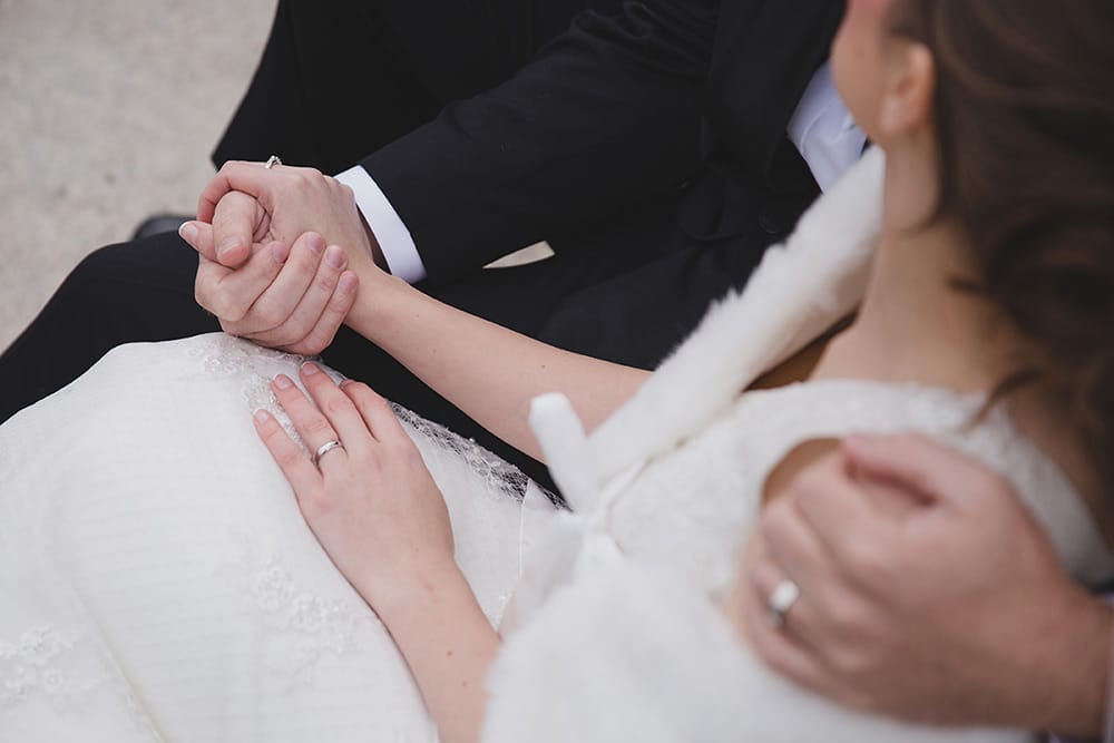 An artistic and natural photograph of a couple holding hands during their wedding portrait session in Boston Public Gardens and Beacon Hill
