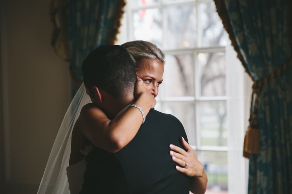 A documentary photograph of a bride hugging her groom when they see each other for the first time before their Taj Boston Hotel Wedding in Massachusetts