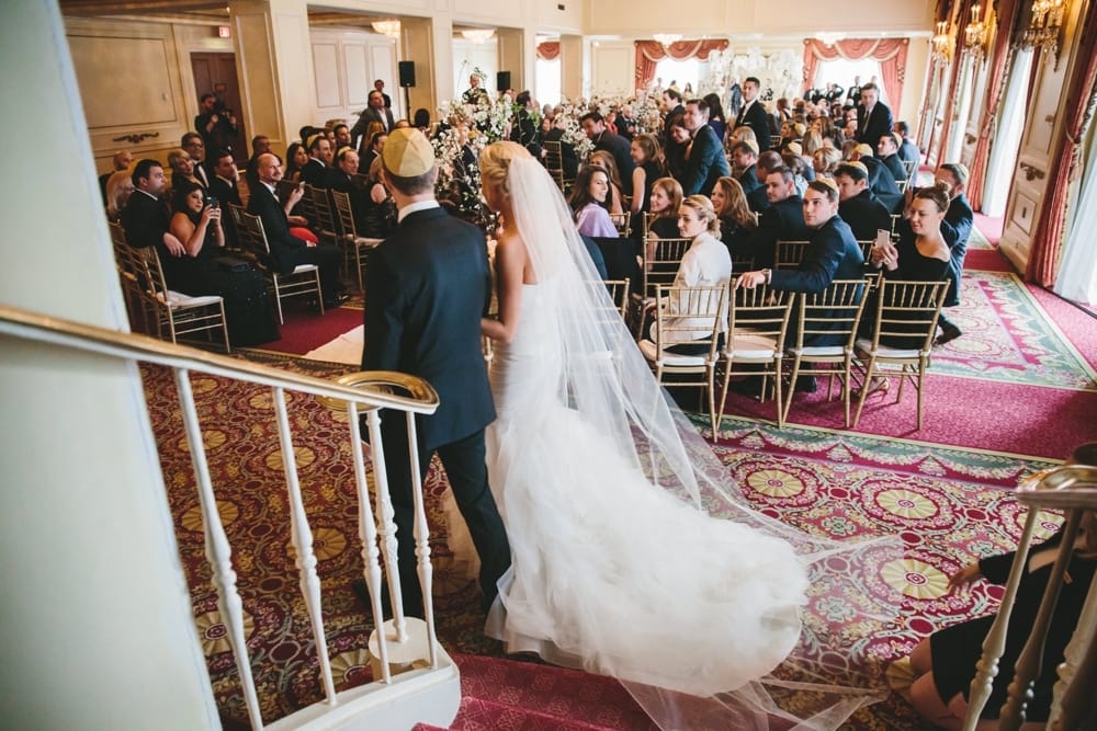 A documentary photograph of a bride walking down the aisle during a Taj Boston Hotel Wedding ceremony in Massachusetts