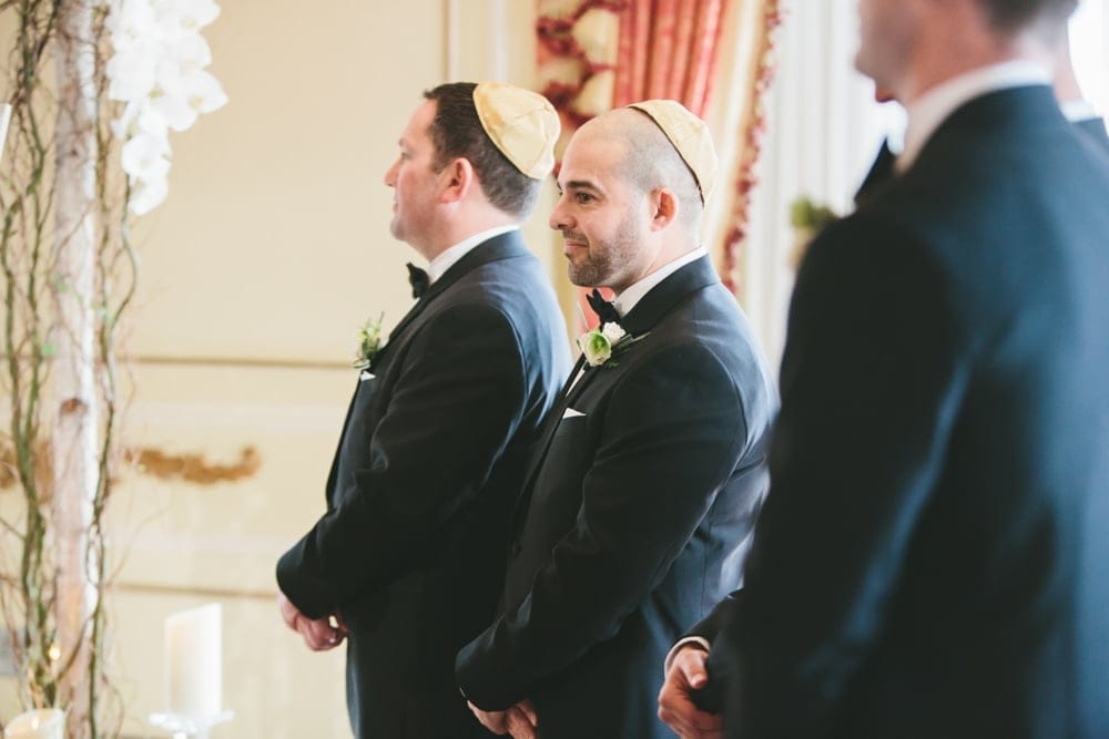 A documentary photograph of Groomsmen watching the ceremony of a Taj Boston Hotel Wedding in Massachusetts