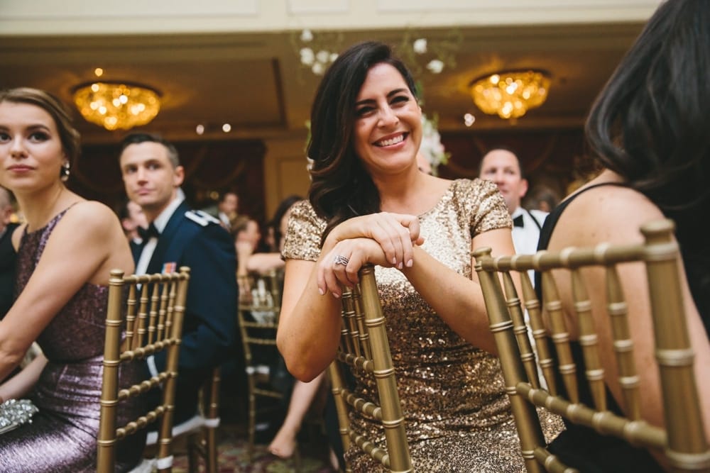 A documentary photograph of a bridesmaid laughing during the best man speech at a Taj Boston Hotel Wedding in Massachusetts