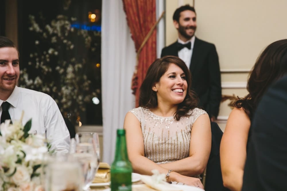 A documentary photograph of a bridesmaid laughing at the best man speech during a Taj Boston Hotel Wedding in Massachusetts