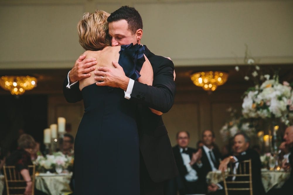A documentary photograph of a groom hugging his mother after their mother son dance at a Taj Boston Hotel Wedding in Massachusetts