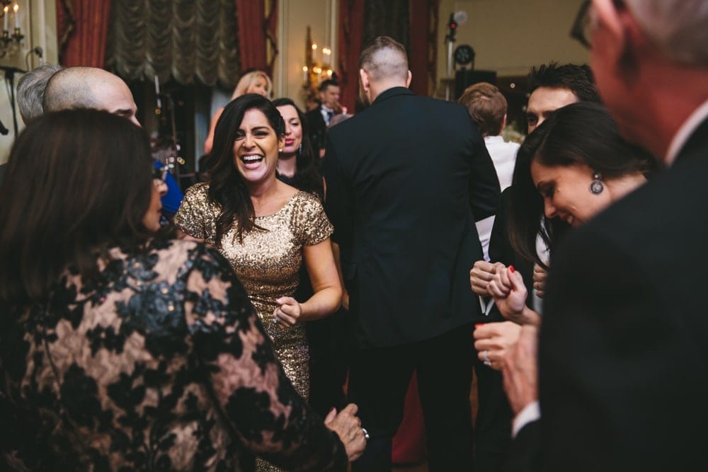 A documentary photograph of guests laughing on the dance floor during a Taj Boston Hotel Wedding in Massachusetts