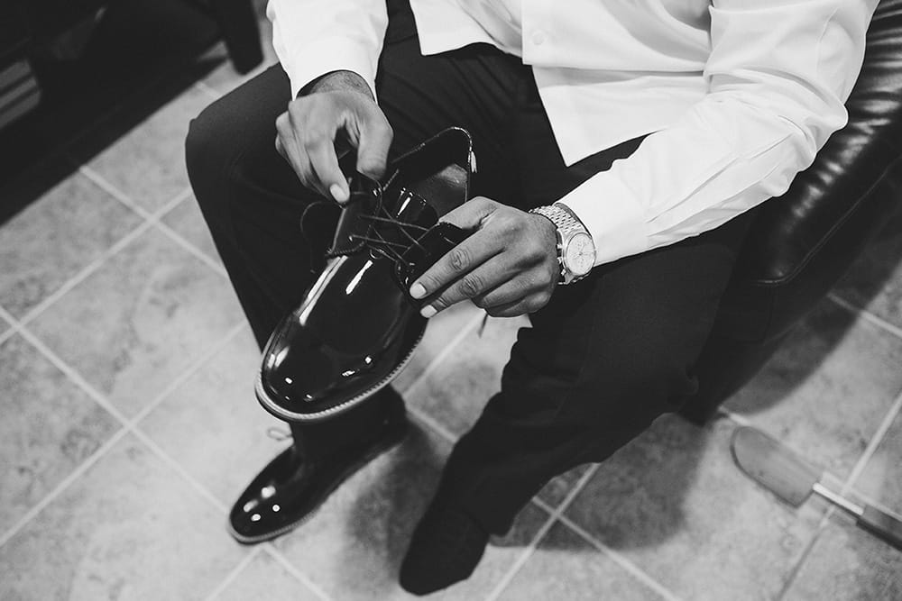 A documentary photograph of a Groomsman putting on his shoe before a Martha's Vineyard Wedding