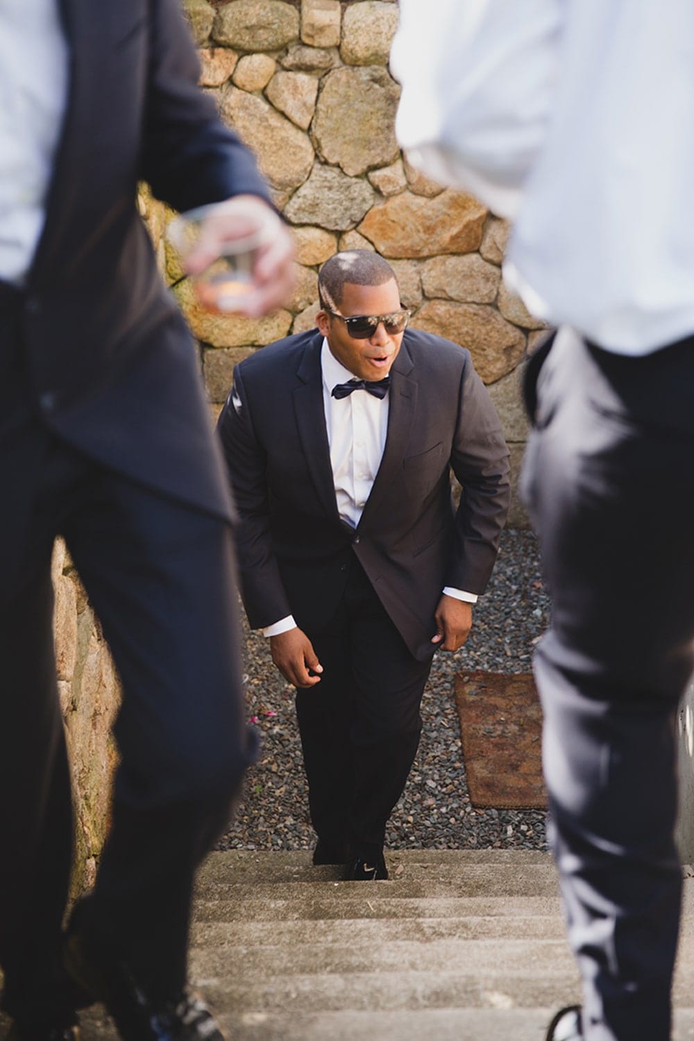 A documentary photograph of Groomsmen walking upstairs before a Martha's Vineyard Wedding