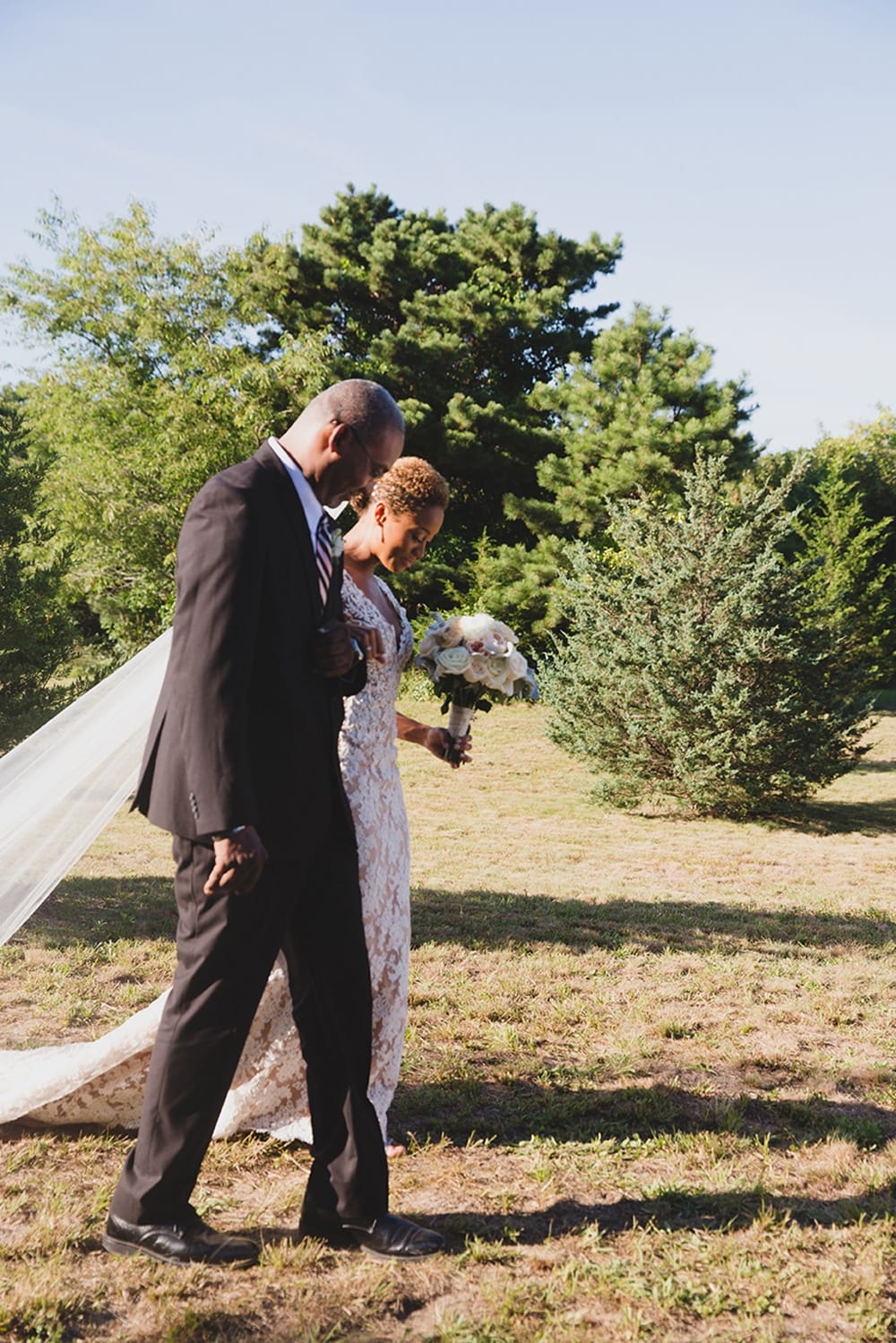 A documentary photograph of a bride walking down the aisle with her father during her Martha's Vineyard Wedding