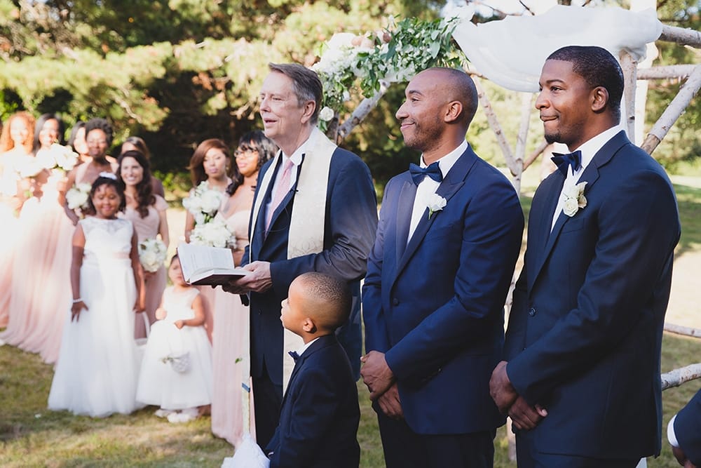 A documentary photograph of a groom watching his bride walk down the aisle during a Martha's Vineyard Wedding