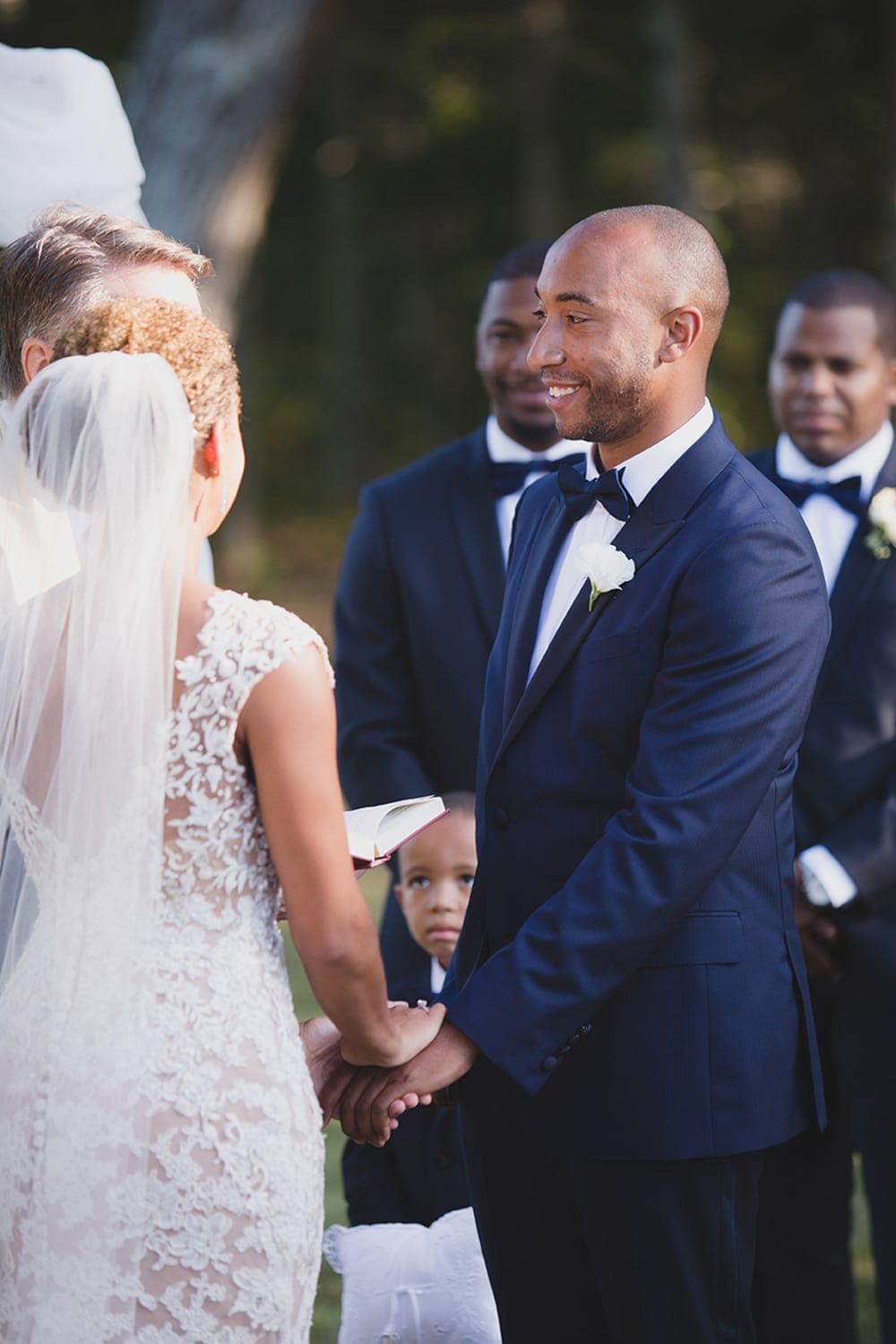 A documentary photograph of a bride and groom exchanging vows during a wedding ceremony on Martha's Vineyard