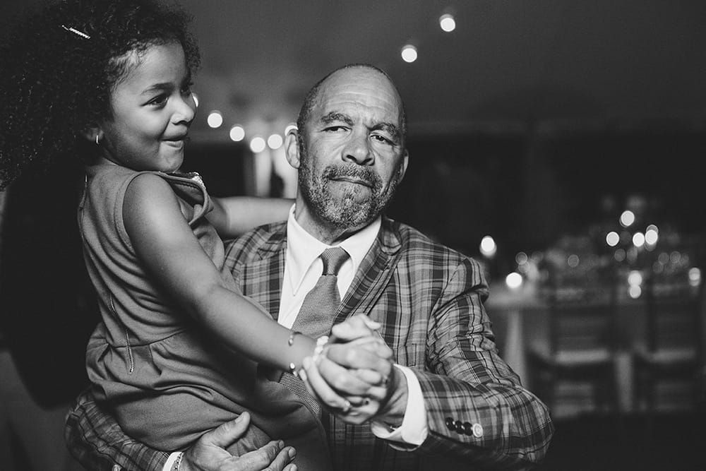 A documentary photograph of a man dancing with a little girl during a Martha's Vineyard Wedding