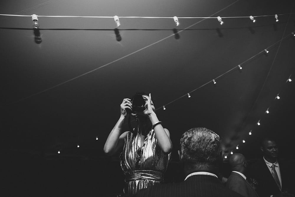 A documentary photograph of a guest taking a photo during a Martha's Vineyard Wedding recpetion