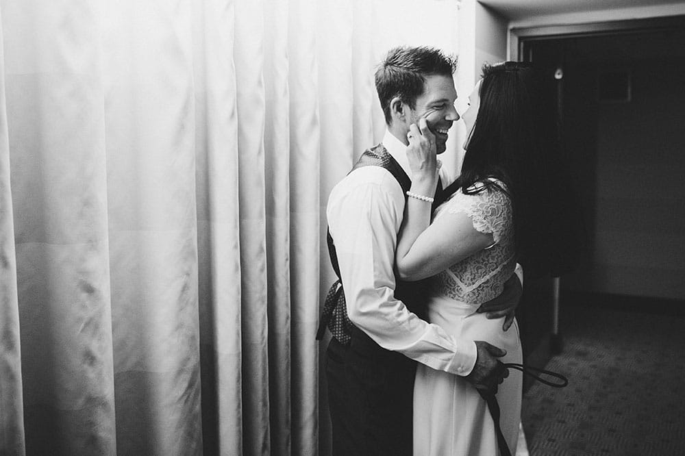 A documentary photograph of a couple kissing in a hallway at Nine Zero Hotel before their Boston Engagement Session