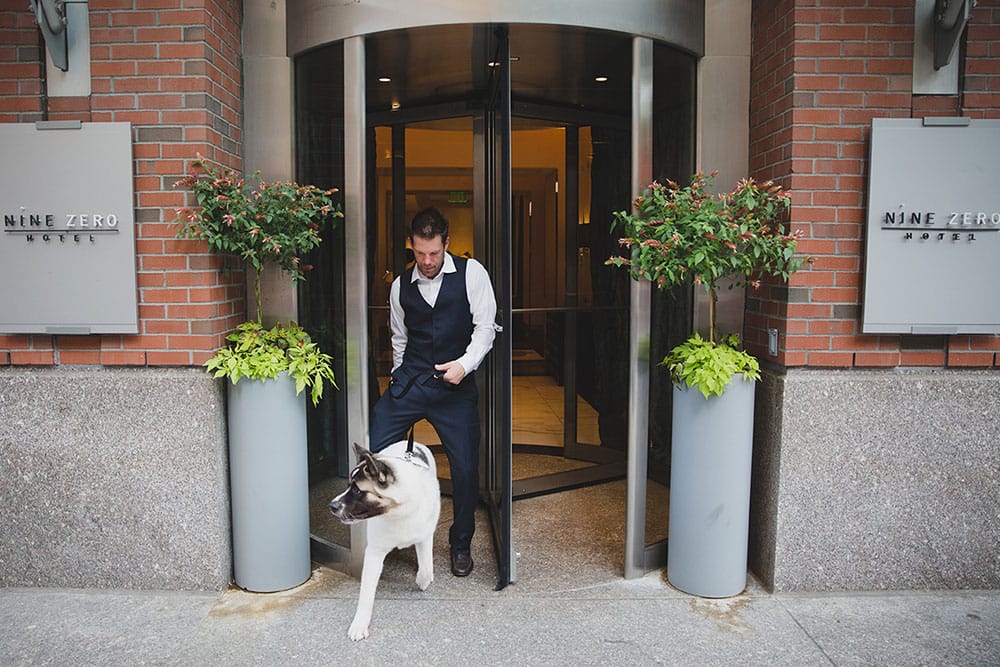 A documentary photograph of a man leaving the Nine Zero Hotel with his dog during his Boston Engagement Session