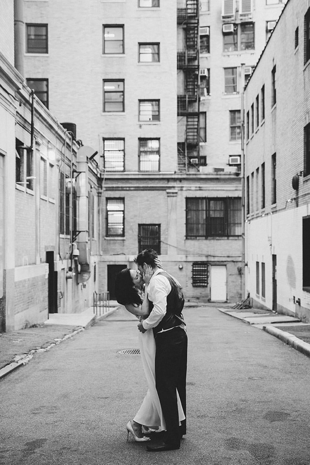 A documentary portrait of a couple kissing in an alleyway during their Boston Engagement Session
