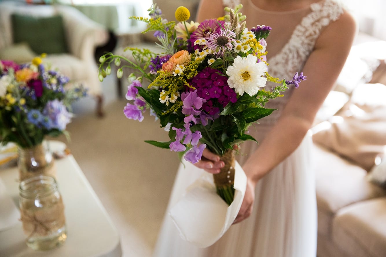 A documentary photograph of a bride drying her bouquet before her Friendly Crossways Wedding