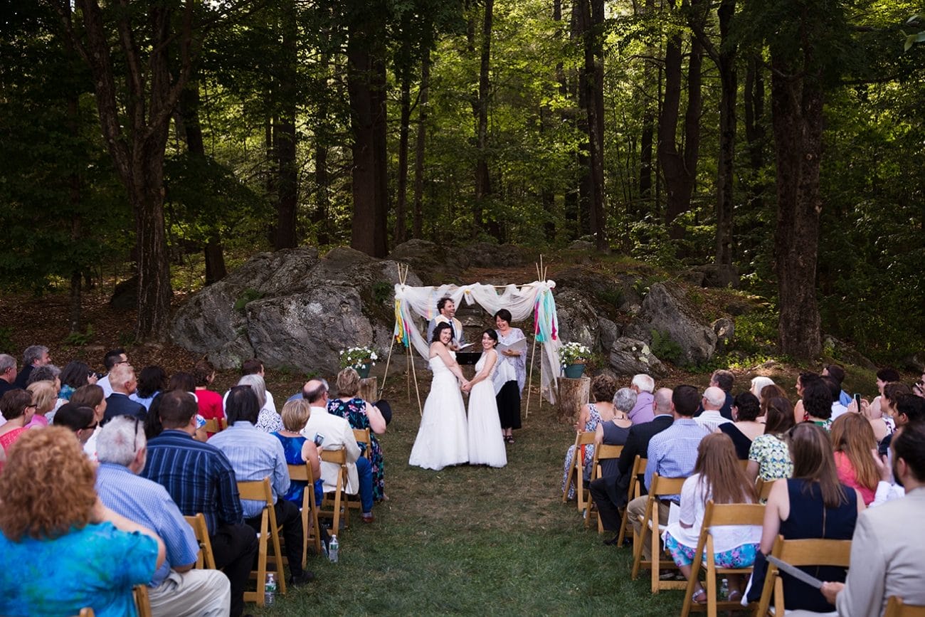 A documentary photograph of two brides during their outdoor wedding ceremony at Friendly Crossways